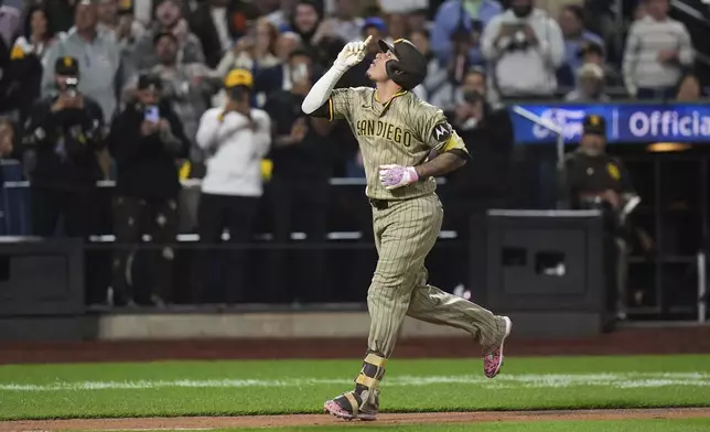 San Diego Padres' Manny Machado gestures as he runs the bases after hitting a grand slam during the fifth inning of a baseball game against the New York Mets Wednesday, Sept. 17, 2025, in New York. (AP Photo/Frank Franklin II)