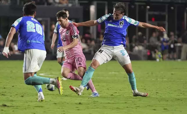 Inter Miami forward Lionel Messi (10) runs with the ball as Seattle Sounders midfielder Kim Kee-hee (20) and midfielder Snyder Brunell, right, defend during the second half of an MLS soccer match, Tuesday, Sept. 16, 2025, in Fort Lauderdale, Fla. (AP Photo/Lynne Sladky)