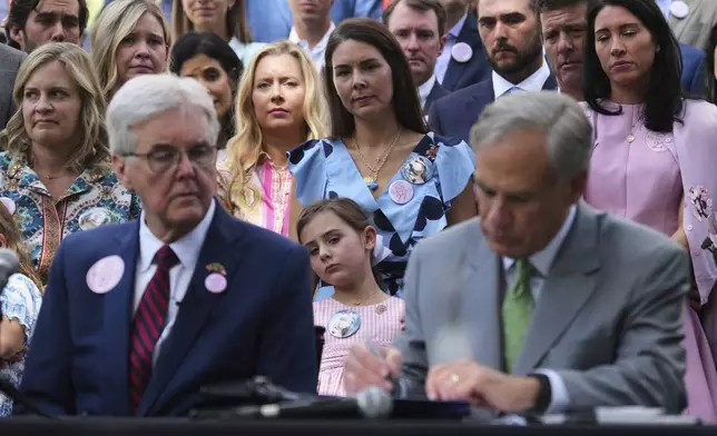 Parents and family of children who died at Camp Mystic, look on as Texas Gov. Greg Abbott signs a camp safety bill, Friday, Sept. 5, 2025, in Austin, Texas. (AP Photo/Eric Gay)