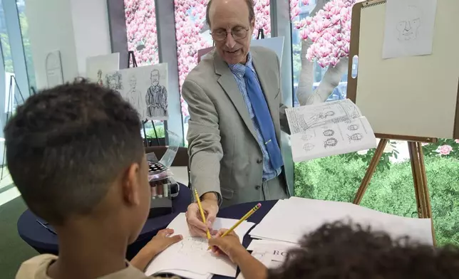 John Hutton, illustrator and professor of art history at Salem College, shows Aidan Santos, 8, of Long Island, N..Y., how to draw a picture of President Abraham Lincoln, Tuesday, Aug. 12, 2025, from his book, "How To Draw The Presidents and First Ladies," at The People's House, a museum in Washington. (AP Photo/Jacquelyn Martin)