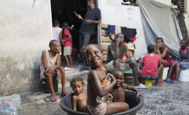 Children bathe at a makeshift shelter for people displaced by gang violence in Port-au-Prince, Haiti, Wednesday, Sept. 17, 2025. (AP Photo/Odelyn Joseph)