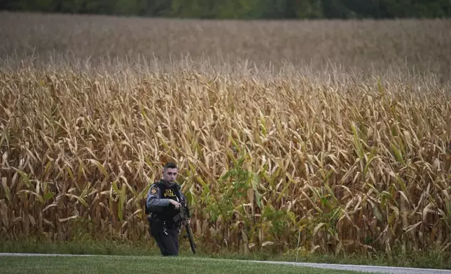A Pennsylvania state police trooper patrols a road after multiple police officers were shot and killed on Wednesday, Sept. 17, 2025, in North Codorus, Pa. (AP Photo/Matt Slocum)