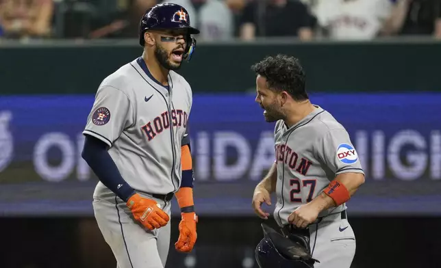 Houston Astros' Carlos Correa, left, and Jose Altuve (27) celebrate after Correa hit a two-run home run that scored Altuve in the eighth inning of a baseball game against the Texas Rangers Friday, Sept. 5, 2025, in Arlington, Texas. (AP Photo/Tony Gutierrez)