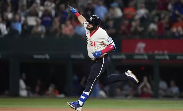 Texas Rangers' Jake Burger celebrates his two-run home run in the third inning of a baseball game against the Houston Astros Friday, Sept. 5, 2025, in Arlington, Texas. (AP Photo/Tony Gutierrez)