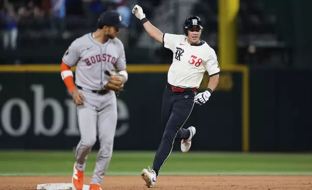 Texas Rangers' Dustin Harris, right, celebrates his game winning double as Houston Astros shortstop Jeremy Pena looks on in the 12th inning of a baseball game Friday, Sept. 5, 2025, in Arlington, Texas. (AP Photo/Tony Gutierrez)
