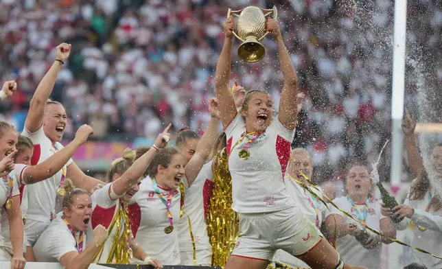 England's Zoe Aldcroft holds a trophy as she celebrates with her teammates after winning the Women's Rugby World Cup final match between England and Canada at the Allianz Stadium, Twickenham, London, Saturday, Sept. 27, 2025. (AP Photo/Alastair Grant)