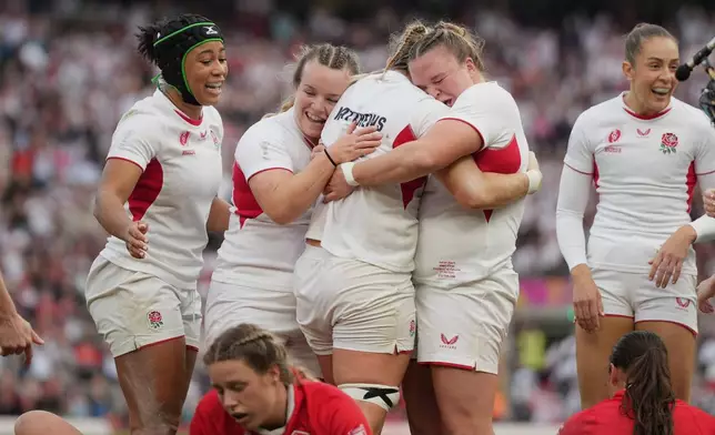 England's Alex Matthews, third left, celebrates with her teammates after scoring a try during the Women's Rugby World Cup final match between England and Canada at the Allianz Stadium, Twickenham, London, Saturday, Sept. 27, 2025. (AP Photo/Alastair Grant)