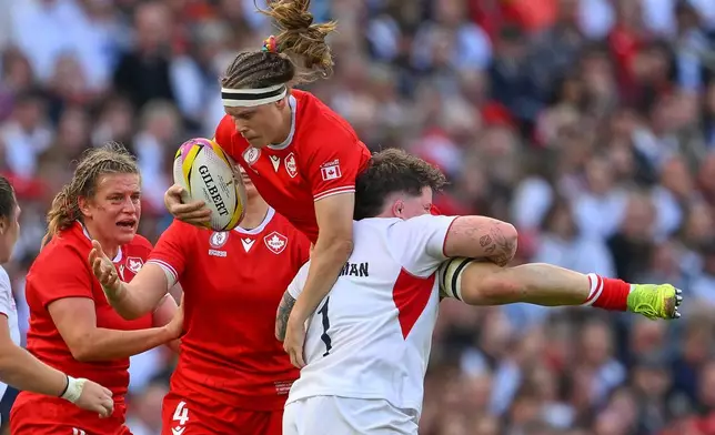England's Hannah Botterman tackles Canada's Karen Paquin during the Women's Rugby World Cup final match between England and Canada at the Allianz Stadium, Twickenham in London, Saturday, Sept. 27, 2025.(AP Photo/Anthony Upton)