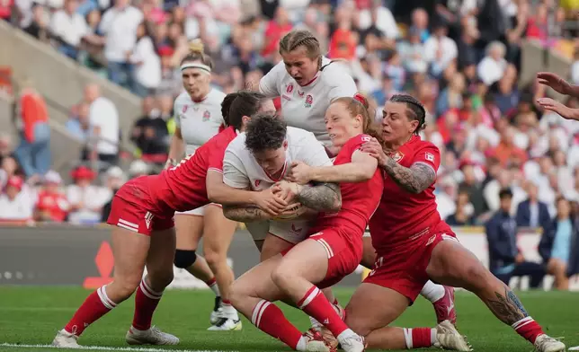 England's Hannah Botterman, centre, try to score a try during the Women's Rugby World Cup final match between England and Canada at the Allianz Stadium, Twickenham, London, Saturday, Sept. 27, 2025. (AP Photo/Alastair Grant)