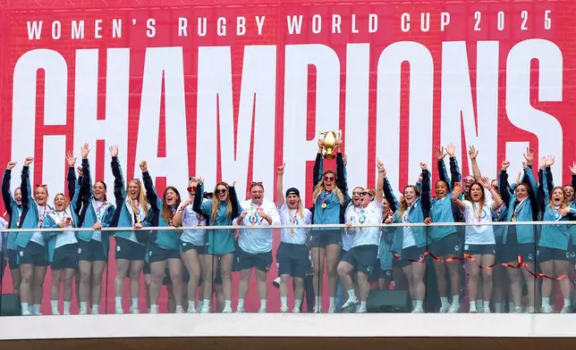 The England team lift the trophy in front of the fans during a Champions Party at Battersea Power Station, London, Sunday, Sept. 28, 2025. England won the Women's World Cup with a 33-13 victory over Canada at Allianz Stadium. (Ben Whitley/PA via AP)