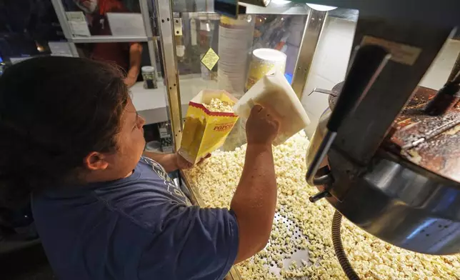 Mason Butz prepares a bag of popcorn in the refreshment stand at the Shankweiler Drive-In before the evening's double feature of "Jaws" and "Twisters" in Orefield, Pa., Friday, Aug. 29, 2025. (AP Photo/Gene J. Puskar)