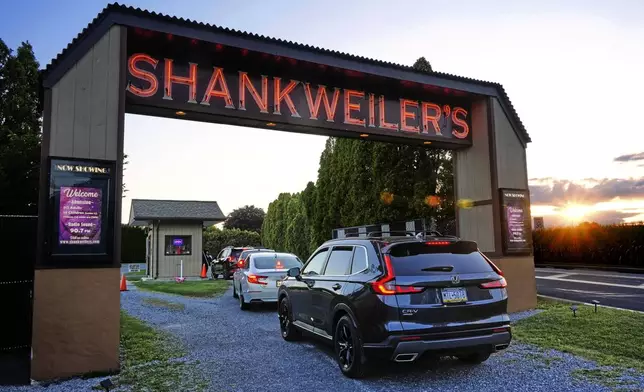 The sun sets on the Shankweiler Drive-In as cars arrive for the evening's double feature of "Jaws" and "Twisters" in Orefield, Pa., Friday, Aug. 29, 2025. (AP Photo/Gene J. Puskar)