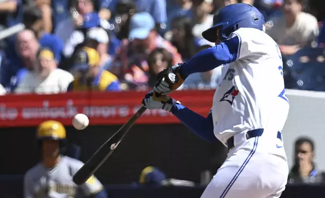 Toronto Blue Jays' Ernie Clement (22) hits an RBI single during the first inning of a baseball game against the Milwaukee Brewers in Toronto on Sunday, Aug. 31, 2025. (Jon Blacker/The Canadian Press via AP)
