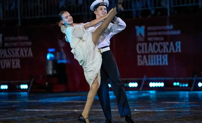 Actors in 1950s clothing perform during the closing ceremony of the Spasskaya Tower International Military Music Festival in Red Square in front of the St. Basil Cathedral in Moscow, Russia, on Sunday, Aug. 31, 2025. (AP Photo/Alexander Zemlianichenko)