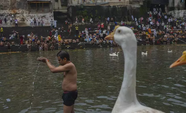 A Hindu devotee performs rituals on the occasion of Mahalaya, an auspicious day to pay homage to ancestors in Mumbai, India, Sunday, Sept. 21, 2025. (AP Photo/Rafiq Maqbool)
