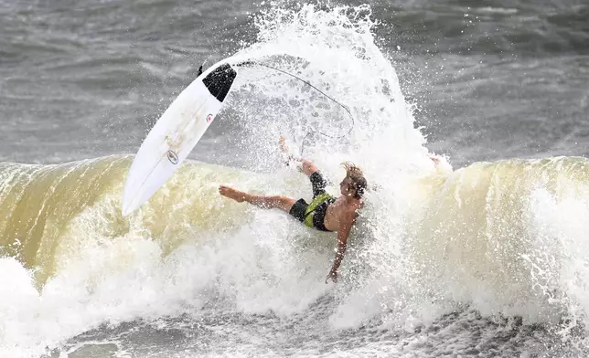 A surfer falls off of his board while taking advantage of the large waves kicked up by Tropical Storm Imelda as it passes offshore, Monday, Sept. 29, 2025, in Satellite Beach, Fla. (AP Photo/Phelan M. Ebenhack)