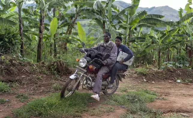 Field nurse Winnie Katwesigye with Reach One Touch One Ministries rides on the back of a motorcycle taxi to check on older patients at their homes in rural areas of the Rukiga District, Uganda, Tuesday, Nov. 19, 2024. (AP Photo/David Goldman)