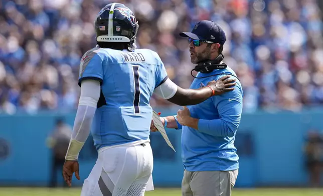 Tennessee Titans head coach Brian Callahan talks with quarterback Cam Ward (1) during the second half of an NFL football game against the Indianapolis Colts Sunday, Sept. 21, 2025, in Nashville, Tenn. (AP Photo/George Walker IV)