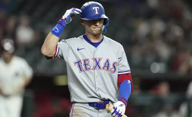 Texas Rangers' Michael Helman walks back to the dugout after being called out on strikes against the Arizona Diamondbacks during the ninth inning of a baseball game Tuesday, Sept. 2, 2025, in Phoenix. (AP Photo/Ross D. Franklin)