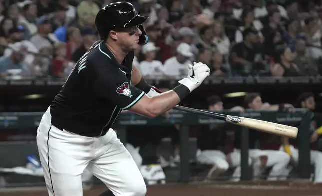 Arizona Diamondbacks' James McCann hits an RBI double against the Philadelphia Phillies in the sixth inning of a baseball game, Saturday, Sept. 20, 2025, in Phoenix. (AP Photo/Rick Scuteri)