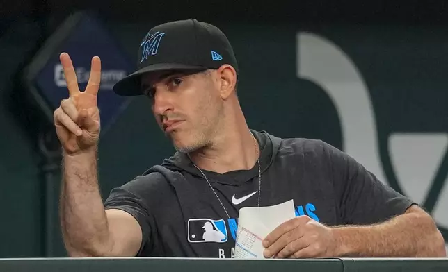 Miami Marlins assistant pitching coach &amp; assistant pitching director Alon Leichman gestures signs toward catcher Agustín Ramírez during the eighth inning of a baseball game Saturday, Sept. 20, 2025, in Arlington, Texas. (AP Photo/Julio Cortez)