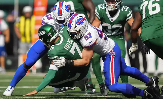 New York Jets quarterback Justin Fields (7) is sacked by Buffalo Bills defensive end Joey Bosa (97) and defensive end Javon Solomon (56) during the fourth quarter of an NFL football game, Sunday, Sept. 14, 2025, in East Rutherford, N.J. (AP Photo/Yuki Iwamura)