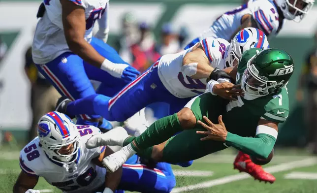 New York Jets quarterback Justin Fields (7) fumbles the ball as he's tackled by Buffalo Bills linebacker Matt Milano (58) and defensive end Joey Bosa (97) during the first quarter of an NFL football game, Sunday, Sept. 14, 2025, in East Rutherford, N.J. (AP Photo/Yuki Iwamura)