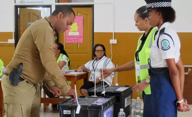 A police officer casts his vote at the English River School in Victoria, Seychelles, Thursday, Sept. 25, 2025. (AP Photo/Emilie Chetty)