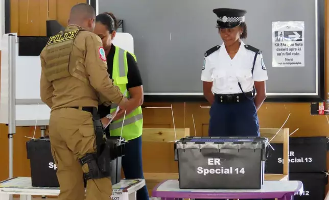 A police officer casts his vote at English River School in Victoria, Seychelles, Thursday, Sept. 25, 2025. (AP Photo/Emilie Chetty)