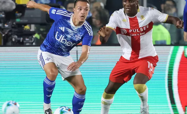 Como's Maxence Caqueret, left, and Genoa's Brooke Norton-Cuffy, right, challenge for the ball during the Serie A soccer match between Como 1907 and CFC Genoa 1893 in Como, Italy, Monday, Sept. 15, 2025. (Antonio Saia/LaPresse via AP)