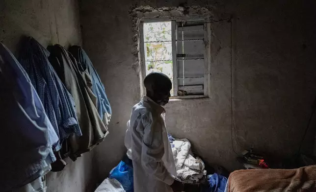 Pafras Jjemba, 88, who barely has anything to eat and survives on the pity of neighbors who give him bananas, stands in his home in Nkulagirire, Uganda, Friday, Nov. 15, 2024. (AP Photo/David Goldman)