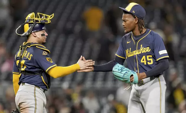 Milwaukee Brewers pitcher Abner Uribe, right, celebrates with catcher William Contreras, left, after getting the final out of a baseball game against the Pittsburgh Pirates, Friday, Sept. 5, 2025, in Pittsburgh. (AP Photo/Matt Freed)