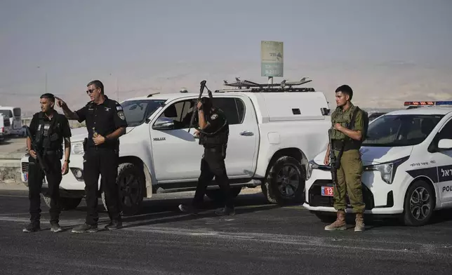 Israeli police and soldiers stand guard near the site of a shooting attack where Israeli officials say two people were shot and killed in a militant attack at the Allenby Bridge Crossing between the West Bank and Jordan, Thursday, Sept. 18, 2025. (AP Photo/Mahmoud Illean)