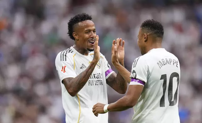 Real Madrid's Eder Militao, left, celebrates with Kylian Mbappe after scoring the opening goal during the Spanish La Liga soccer match between Real Madrid and Espanyol at the Santiago Bernabeu stadium in Madrid, Spain, Saturday, Sept. 20, 2025. (AP Photo/Manu Fernandez)