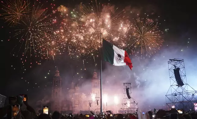 People watch fireworks during the Independence Day celebration at the Zocalo, Mexico City's main square, Monday, Sept. 15, 2025. (AP Photo/Jon Orbach)
