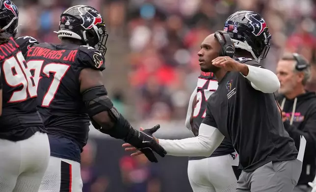 Houston Texans head coach DeMeco Ryans, right, congratulates defensive tackle Mario Edwards (97) after a sack during the first half of an NFL football game against the Tennessee Titans, Sunday, Sept. 28, 2025, in Houston. (AP Photo/Ashley Landis)