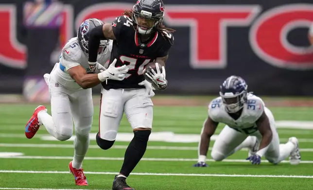 Houston Texans cornerback Derek Stingley Jr. (24) returns an interception as he is tackled by Tennessee Titans wide receiver Elic Ayomanor (5) during the second half of an NFL football game Sunday, Sept. 28, 2025, in Houston. (AP Photo/Ashley Landis)