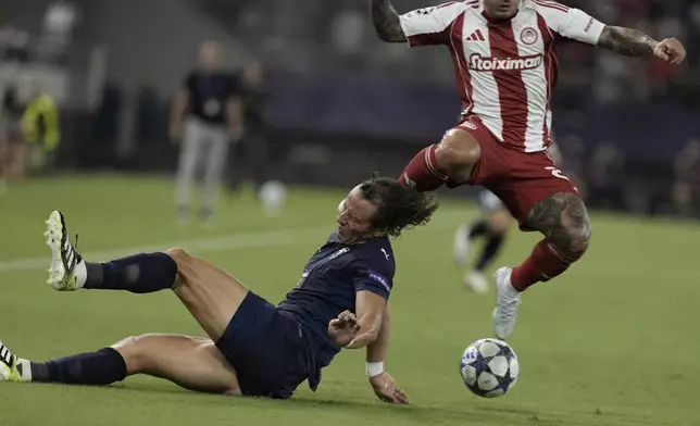 Pafos' David Luiz is hit by Olympiacos' Gabriel Strefezza during a Champions League opening phase soccer match between Olympiakos and Pafos at the Georgios Karaiskakis stadium, Piraeus port, near Athens, Greece, Wednesday, Sept. 17, 2025. (AP Photo/Petros Giannakouris)