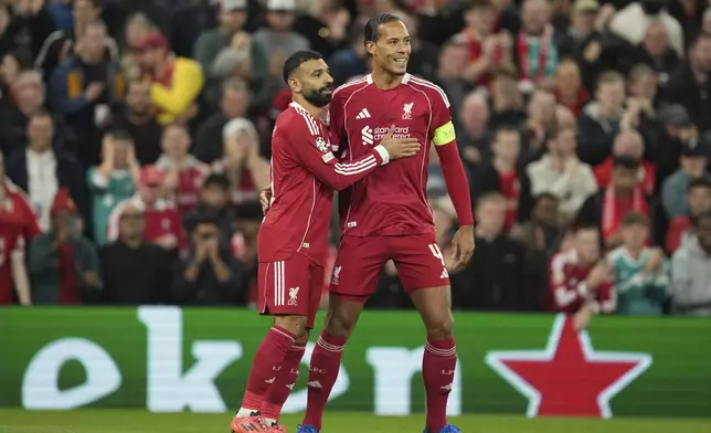 Liverpool's Mohamed Salah, left, celebrates with his teammate Virgil van Dijk after scoring his side's second goal during the Champions League opening phase soccer match between Liverpool and Atletico Madrid at Anfield stadium in Liverpool, England, Wednesday, Sept. 17, 2025. (AP Photo/Jon Super)