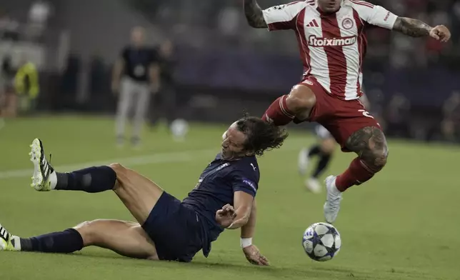 Pafos' David Luiz is hit by Olympiacos' Gabriel Strefezza during a Champions League opening phase soccer match between Olympiakos and Pafos at the Georgios Karaiskakis stadium, Piraeus port, near Athens, Greece, Wednesday, Sept. 17, 2025. (AP Photo/Petros Giannakouris)