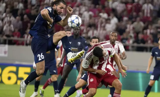 Pafos' Ivan Sunjic fights for the ball against Olympiacos' Francisco Ortega during a Champions League opening phase soccer match between Olympiakos and Pafos at the Georgios Karaiskakis stadium, Piraeus port, near Athens, Greece, Wednesday, Sept. 17, 2025. (AP Photo/Petros Giannakouris)