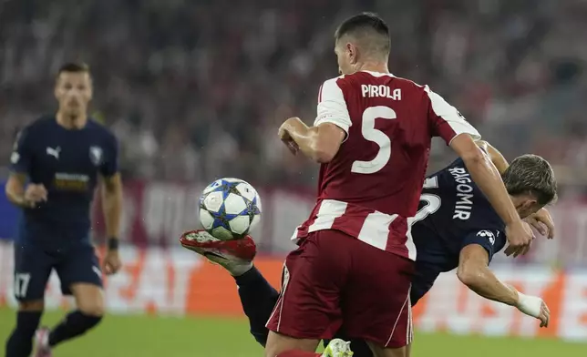 Pafos' Vlad Dragomir fights for the ball against Pafos' David Goldar during a Champions League opening phase soccer match between Olympiakos and Pafos at the Georgios Karaiskakis stadium, Piraeus port, near Athens, Greece, Wednesday, Sept. 17, 2025. (AP Photo/Petros Giannakouris)