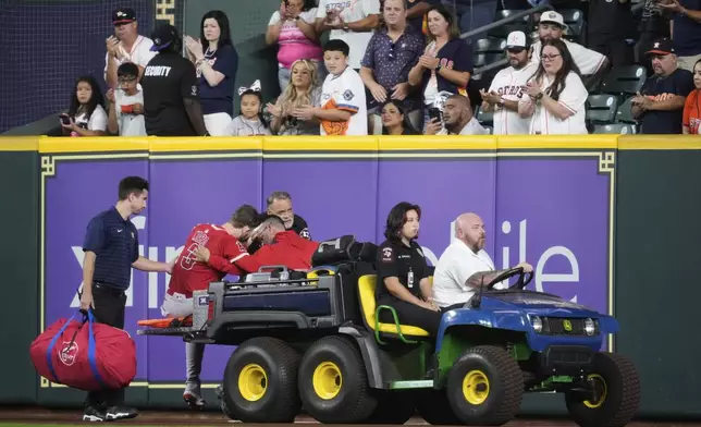 Los Angeles Angels left fielder Taylor Ward (3) is treated for injury during the eighth inning of a baseball game against the Houston Astros in Houston, Sunday, Aug. 31, 2025. (AP Photo/Ashley Landis)