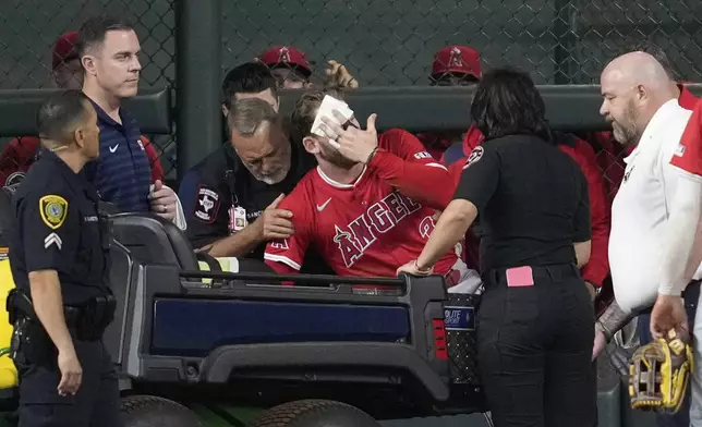 Los Angeles Angels left fielder Taylor Ward, center, is treated for injury during the eighth inning of a baseball game against the Houston Astros in Houston, Sunday, Aug. 31, 2025. (AP Photo/Ashley Landis)