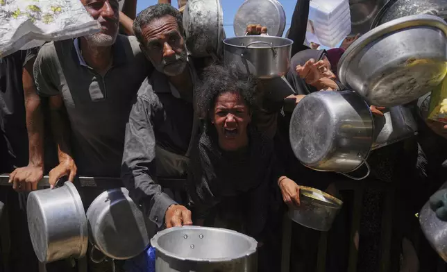 Palestinians struggle to get donated food at a community kitchen in Khan Younis, southern Gaza Strip, Monday, Sept. 1, 2025. (AP Photo/Abdel Kareem Hana)