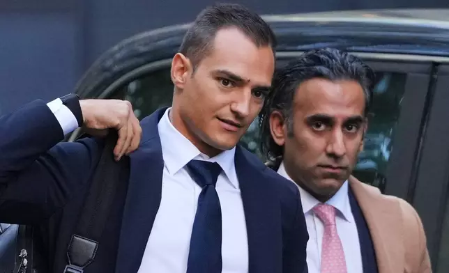 IndyCar champion Alex Palou, left, with legal representative Kavan Bakhda arrive at court at the start of a breach of contract lawsuit with McLaren Racing, in London, Monday, Sept. 29, 2025. (AP Photo/Kirsty Wigglesworth)