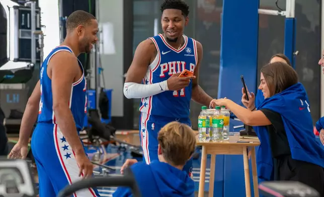 Philadelphia 76ers' Justin Edwards, center, and Eric Gordon play around with a social media station during the NBA basketball team's media day, Friday, Sept. 26, 2025, in Camden, N.J. (AP Photo/Chris Szagola)