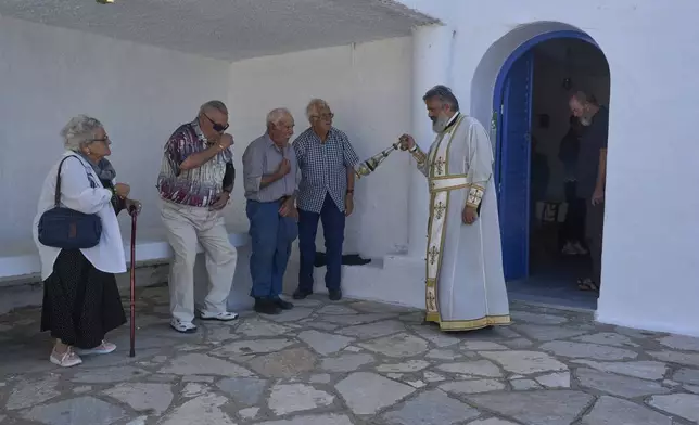 An Orthodox priest swings a censer during a liturgy at the family-owned Agios Sostis chapel on the island of Tinos, Greece, Monday, Sept. 8, 2025. (AP Photo/Petros Giannakouris)