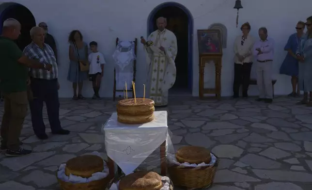 Greek Orthodox priest Antonios Stathopoulos swings a censer during a liturgy at the family-owned Agios Sostis chapel on the island of Tinos, Greece, Monday, Sept. 8, 2025. (AP Photo/Petros Giannakouris)