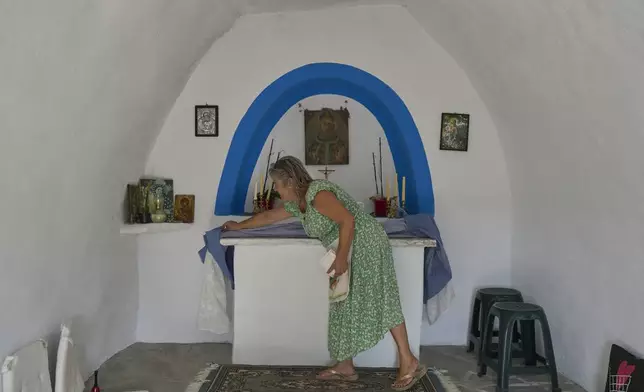 Bernadette Foskolos cleans her Agios Athanasios family-owned chapel at the village of Steni, on Tinos island, Greece, Saturday, Sept. 6, 2025. (AP Photo/Petros Giannakouris)